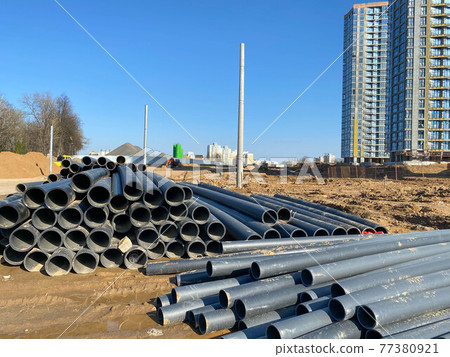 Warehouse of finished plastic pipes industrial outdoors storage site. Manufacture of plastic water pipes factory 77380921