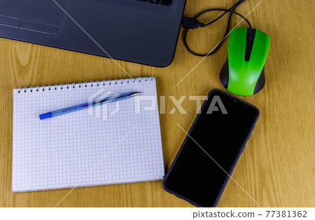 Laptop with mouse, smartphone, notebook and pen on a desk. Top view. Working at home and business concept Laptop with mouse, smartphone, notebook and pen on a desk. Top view. Working at home and business concept 77381362