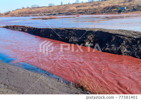 Technical settler of industrial water of mining industry in Kryvyi Rih, Ukraine. Red water polluted with iron ore waste. Discharge of process water in the sump after the iron ore beneficiation Technical settler of industrial water of mining industry in Kryvyi Rih, Ukraine. Red water polluted with iron ore waste. Discharge of process water in the sump after the iron ore beneficiation 77381401