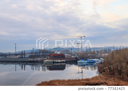 View of the Dnieper river and construction cranes on right bank in Kiev, Ukraine View of the Dnieper river and construction cranes on right bank in Kiev, Ukraine 77381425