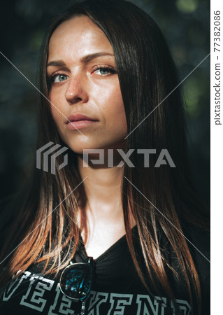 Portrait of a beautiful girl with gray eyes in a black t-shirt looking directly at the camera 77382086