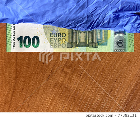 Blue latex gloves and 100 euro bill. Flat lay. For the cashier or seller, sale. Orange background Blue latex gloves and 100 euro bill. Flat lay. For the cashier or seller, sale. Orange background 77382131