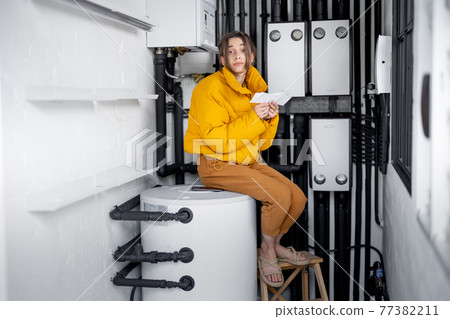 Woman checking bills for electricity at home 77382211