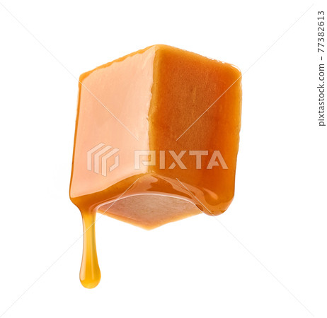 caramel sauce flowing on flying caramel candy 77382613