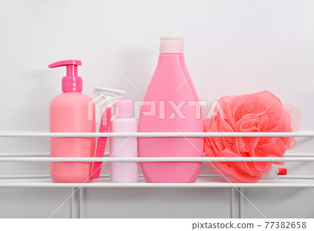 Pink bottles of hygiene toiletries in white bath 77382658