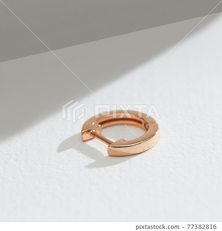 gold earring on a white background gold earring on a white background 77382816