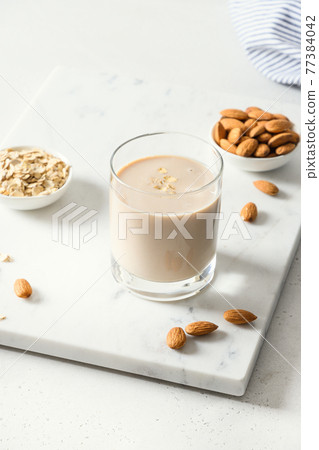 Almond and oatmeal milk on white background. 77384042