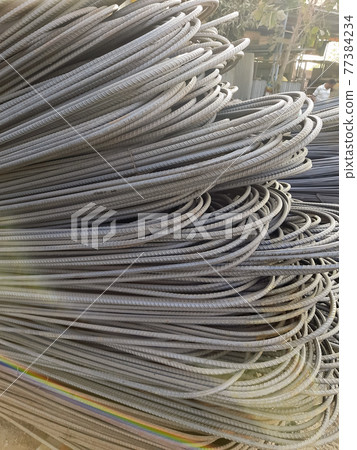 Stack of heavy metal reinforcement bars with periodic profile texture. Close up steel construction armature. Abstract industrial background concept. Copy space. Stack of heavy metal reinforcement bars with periodic profile texture. Close up steel construction armature. Abstract industrial background concept. Copy space. 77384234