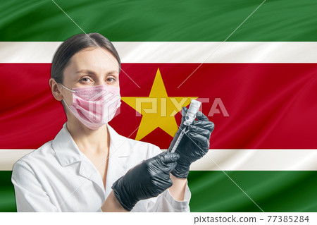 Girl doctor prepares vaccination against the background of the Suriname flag. Vaccination concept Suriname Girl doctor prepares vaccination against the background of the Suriname flag. Vaccination concept Suriname 77385284