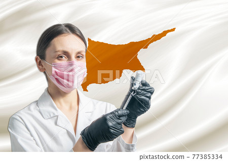 Girl doctor prepares vaccination against the background of the Cyprus flag. Vaccination concept Cyprus Girl doctor prepares vaccination against the background of the Cyprus flag. Vaccination concept Cyprus 77385334