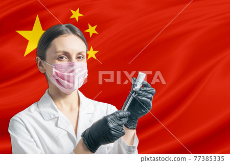 Girl doctor prepares vaccination against the background of the People's Republic of China flag. Vaccination concept People's Republic of China Girl doctor prepares vaccination against the background of the People's Republic of China flag. Vaccination concept People's Republic of China 77385335