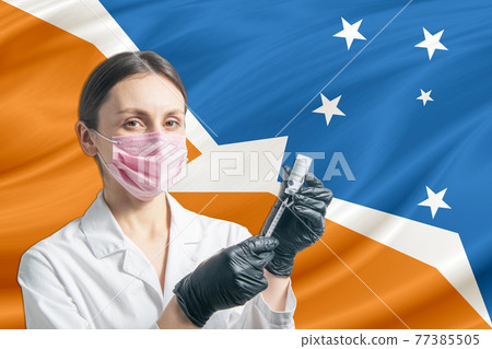 Girl doctor prepares vaccination against the background of the Argentine Antarctica flag. Vaccination concept Argentine Antarctica Girl doctor prepares vaccination against the background of the Argentine Antarctica flag. Vaccination concept Argentine Antarctica 77385505