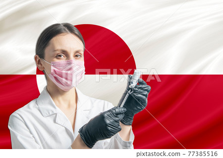 Girl doctor prepares vaccination against the background of the Greenland flag. Vaccination concept Greenland Girl doctor prepares vaccination against the background of the Greenland flag. Vaccination concept Greenland 77385516
