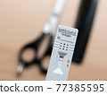 Testing Before Visiting The Hairdresser: Rapid Antigen Corona Test Showing A Negative Result In Front of Scissors and Comb 77385595