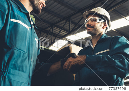 Two skillful factory engineer or worker showing teamwork and partnership . 77387696