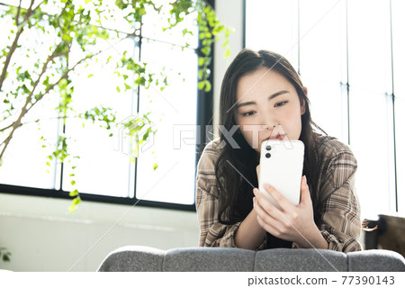 在智能手機上搜索的年輕女性擔心 77390143