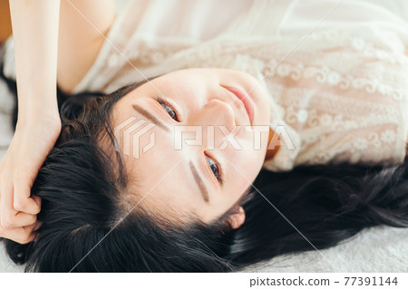 A woman lying in bed 77391144
