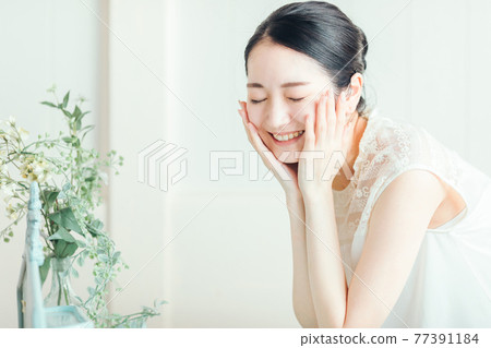洗臉並保養皮膚的女性 洗臉並保養皮膚的女性 77391184