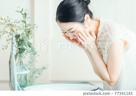 洗臉並保養皮膚的女性 77391185