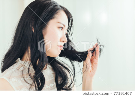 A woman who touches her hair (problem) A woman who touches her hair (problem) 77391407