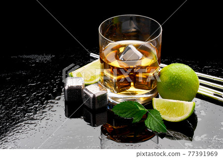 Whiskey with steel cooling cubes on dark glass background 77391969