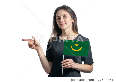 Happy young white woman holding flag Mauritania and points to the left isolated on a white background Happy young white woman holding flag Mauritania and points to the left isolated on a white background 77392264