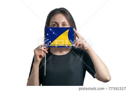 Happy young white woman holding flag Tokelau flag and covers her face with it isolated on a white background Happy young white woman holding flag Tokelau flag and covers her face with it isolated on a white background 77392327