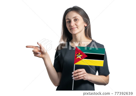 Happy young white woman holding flag Mozambique and points to the left isolated on a white background 77392639
