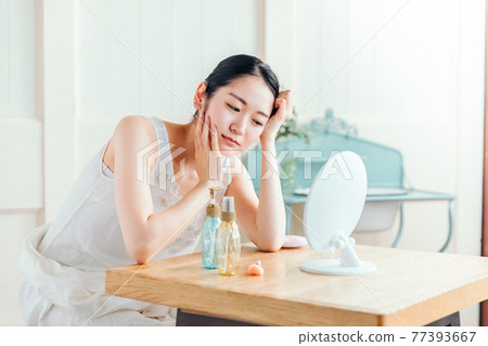 一個女人患有皮膚粗糙與梳妝台 一個女人患有皮膚粗糙與梳妝台 77393667