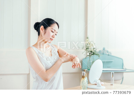 Woman applying body cream (problem) 77393679
