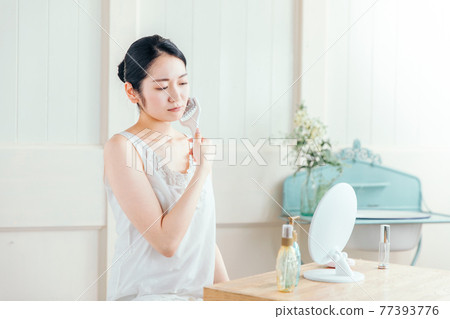 A woman who uses a facial roller (problem) 77393776