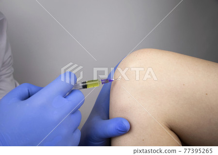 An orthopedic surgeon gives an injection in the knee. Treatment of osteoarthritis with hormonal drugs or drugs based on hyaluronic acid. Help with diseases that damage the cartilage of the joint 77395265