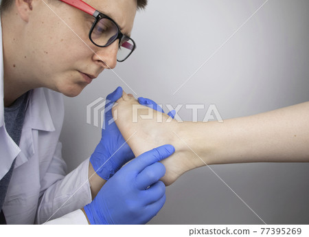 The podiatrist examines the heel and its ridges in a patient who complains of acute pain. Suspected plantar fasciitis, achillodynia, or heel spur. The podiatrist examines the heel and its ridges in a patient who complains of acute pain. Suspected plantar fasciitis, achillodynia, or heel spur. 77395269
