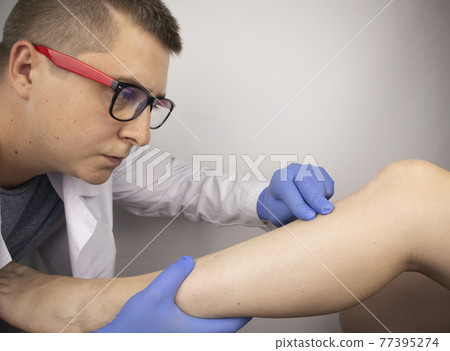 The podiatrist examines the tibia of a patient who complains of pain in it. The concept of diagnostics of bone microcracks and latent course of diseases 77395274