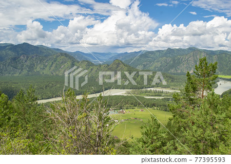 river valley landscape among large, high, steep mountains in sunny clear weather with lots of clouds 77395593
