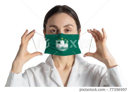 Respirator with flag of Macau Doctor puts on medical face mask isolated on white background 77396997