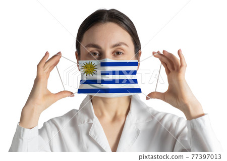 Respirator with flag of Uruguay Doctor puts on medical face mask isolated on white background Respirator with flag of Uruguay Doctor puts on medical face mask isolated on white background 77397013