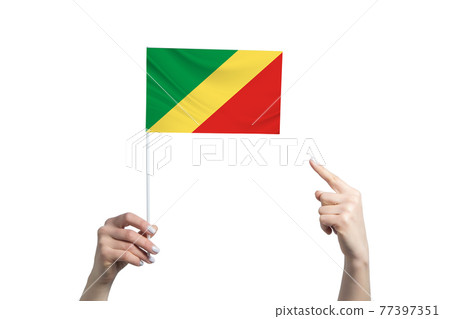 A beautiful female hand holds a Republic of the Congo flag to which she shows the finger of her other hand, isolated on white background A beautiful female hand holds a Republic of the Congo flag to which she shows the finger of her other hand, isolated on white background 77397351