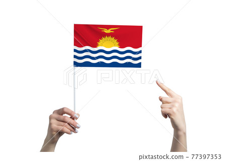 A beautiful female hand holds a Kiribati flag to which she shows the finger of her other hand, isolated on white background 77397353