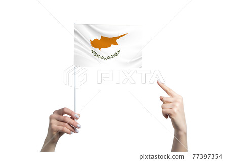 A beautiful female hand holds a Cyprus flag to which she shows the finger of her other hand, isolated on white background A beautiful female hand holds a Cyprus flag to which she shows the finger of her other hand, isolated on white background 77397354