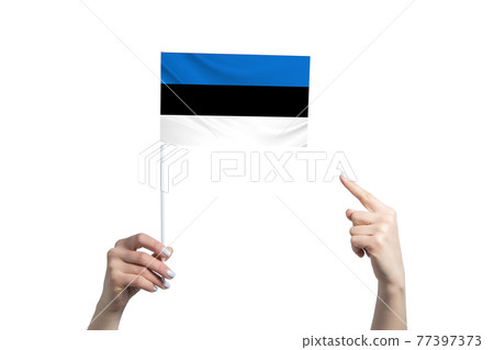 A beautiful female hand holds a Estonia flag to which she shows the finger of her other hand, isolated on white background A beautiful female hand holds a Estonia flag to which she shows the finger of her other hand, isolated on white background 77397373