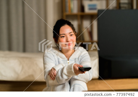 A young woman watching TV A young woman watching TV 77397492