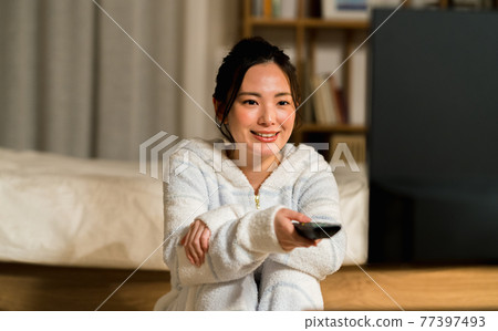 A young woman watching TV A young woman watching TV 77397493