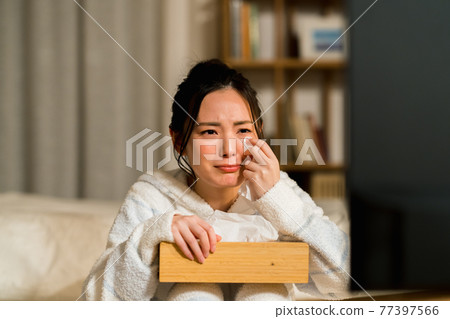 A young woman who is impressed by watching TV 77397566