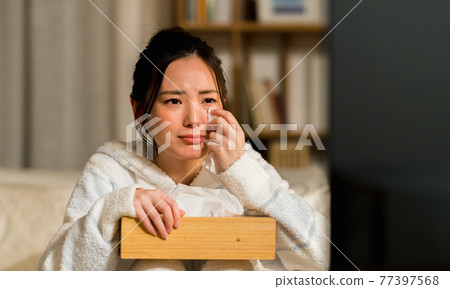 A young woman who is impressed by watching TV 77397568