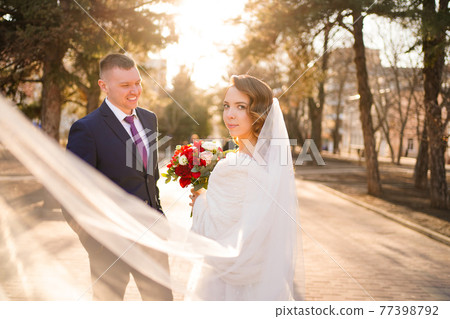 portrait of loving and happy newlywed. wedding dress with long veil 77398792