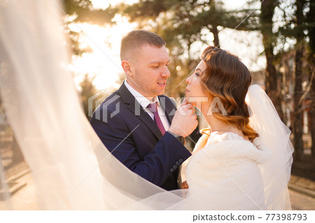 portrait of loving and happy newlywed. wedding fashion. dress with long veil 77398793