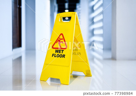 Sign showing warning of wet floor on wet floor Sign showing warning of wet floor on wet floor 77398984