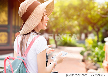 girl teen travel happy smile, Asian women tourist walking with hat backpack bag and camera girl teen travel happy smile, Asian women tourist walking with hat backpack bag and camera 77399317