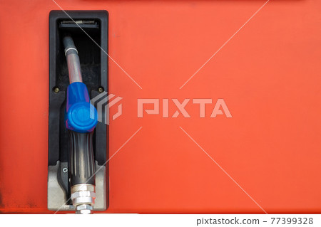 Fuel nozzle at Gas station dispensers or bowsers at for refill car engine gasoline with space for text 77399328